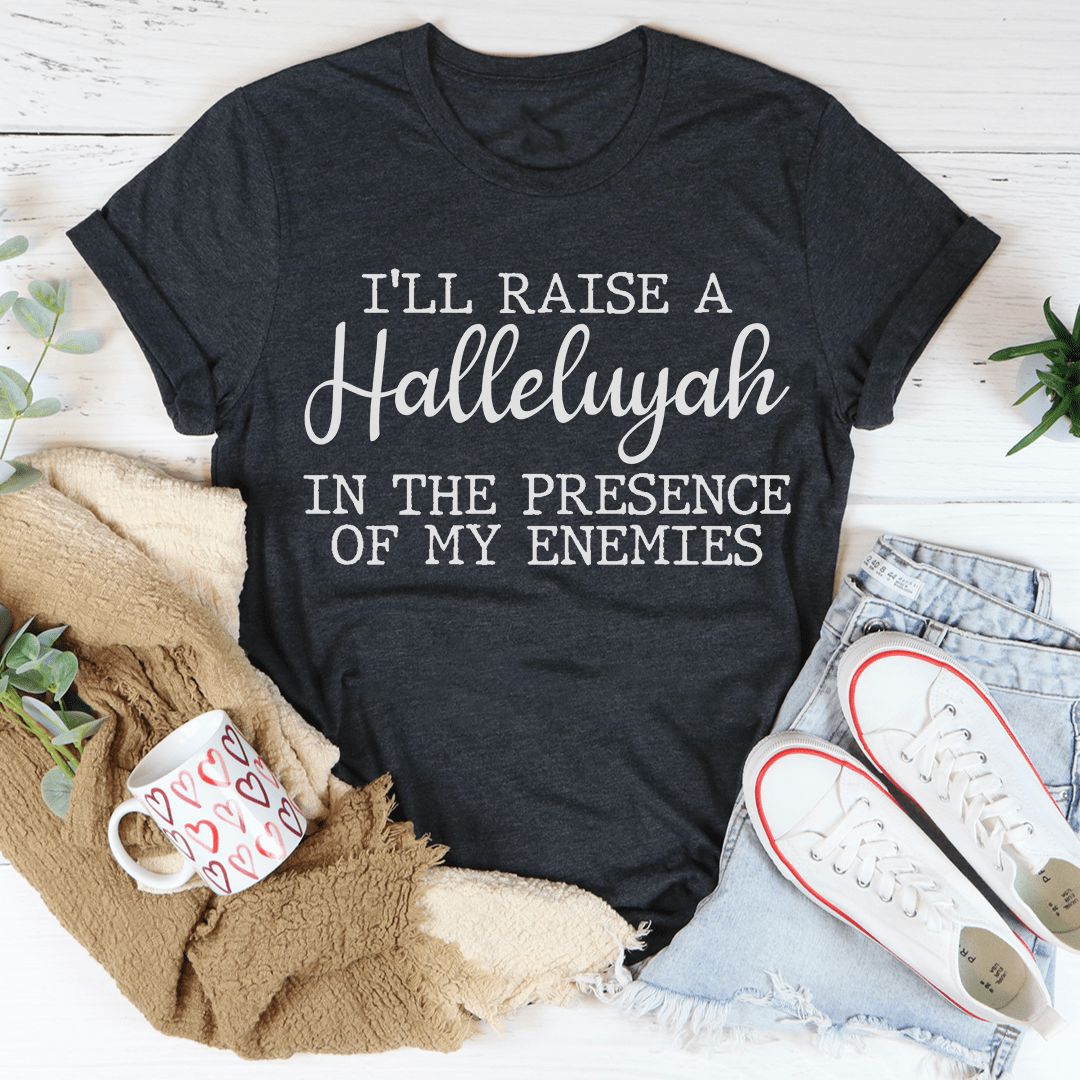 A black t-shirt featuring the phrase 'I'll Raise A Halleluyah In The Presence Of My Enemies' printed in white, showcasing a stylish and comfortable design.